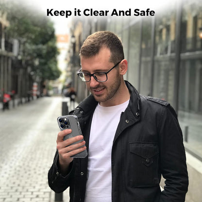 Person holding iPhone 14 Pro Max encased in Motivecase Crystal Clear Series transparent protective cover on city street highlighting clear design. **(21 words)**