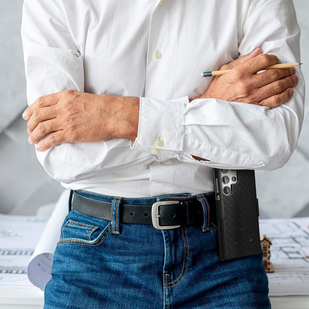 Professional architect at construction workstation using Motivecase Ranger V1 phone holster attached securely to leather waist belt.